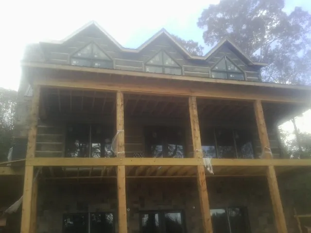 Dormers and porch framing on a large log home under construction — Roof Coating work by our crew in Miamisburg