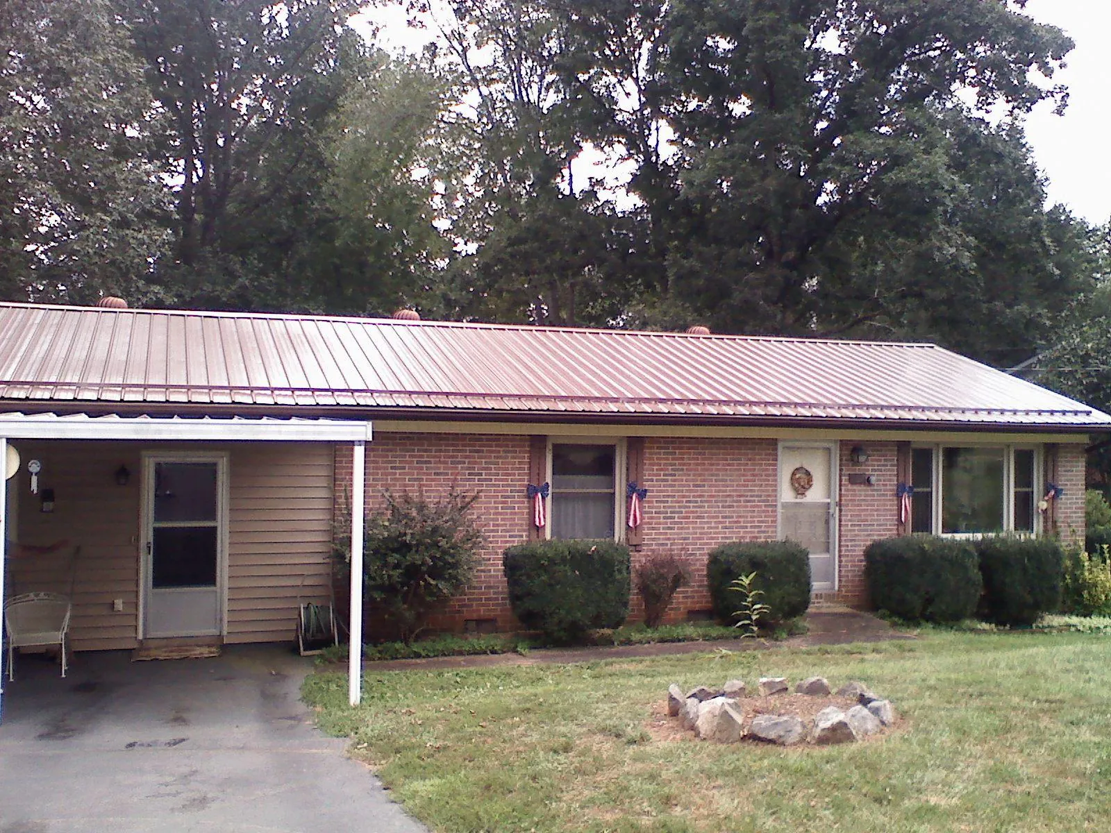 Bronze metal roof and carport on a brick ranch home — Roof Repair work by our crew in Miamisburg